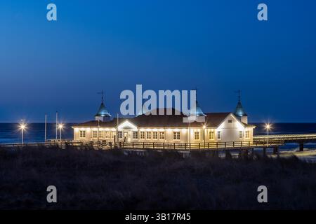 Restaurant sur Ahlbeck Pier/ Seebrücke Ahlbeck illuminé au crépuscule dans la mer Baltique sur l'île d'Usedom, Mecklembourg-Poméranie occidentale, la plus ancienne jetée d'Allemagne Banque D'Images