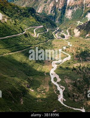Vue panoramique sur le col de Furka, Suisse, avec route de montagne sinueuse à travers les Alpes suisses sous un ciel d'été clair. Banque D'Images
