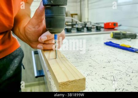 vissez la vis dans la planche avec un tournevis à cheval. Banque D'Images