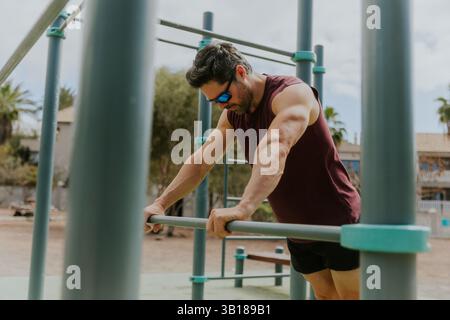 Portrait d'un homme lors d'une séance d'entraînement intense dans un gymnase extérieur calisthenics. Banque D'Images