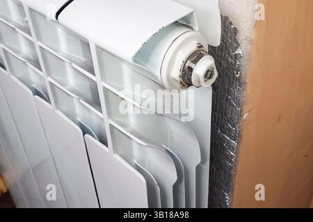 Radiateur de chauffage blanchi à la blanc contre le mur. Banque D'Images