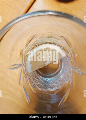 verre transparent avec de l'eau et du citron sur fond en bois Banque D'Images