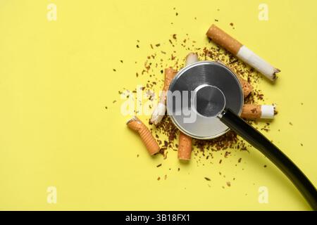 Mégots de cigarettes, tabac et stéthoscope sur fond jaune. Pas de concept de journée du tabac Banque D'Images
