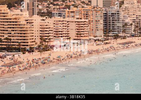 Vue panoramique de Calp (Calpe), Costa Blanca, Espagne, avec plage de sable, mer Méditerranée turquoise, et des bâtiments modernes en arrière-plan. Banque D'Images