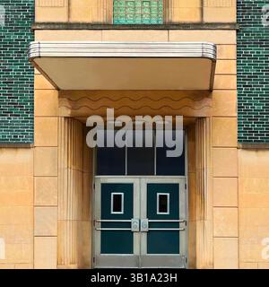 Streamline style moderne entrée avec doubles portes vertes, accents de blocs de verre, verrière sculptée et façade géométrique en pierre à Chicago Banque D'Images