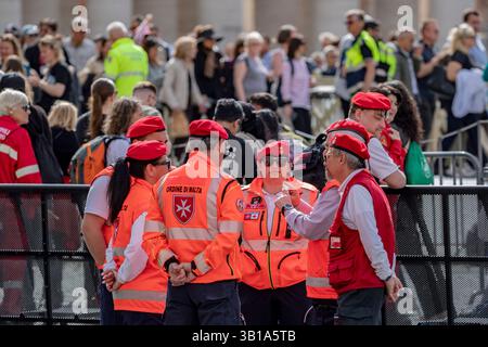 Cité du Vatican, Europe du Sud. 25 avril 2025. Les membres de l’ordre de Malte, vêtus de bérets rouges et de vestes orange, coordonnent le soutien de la foule et l’assistance médicale à la Cité du Vatican le vendredi 25 avril 2025, la veille des funérailles du pape François. (VX photo/ Vudi Xhymshiti) crédit : VX Pictures/Alamy Live News Banque D'Images