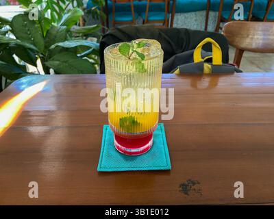 Sunrise Mojito, boisson rafraîchissante avec un mélange de couleur jaune et rouge servi sur des montagnes russes bleues Banque D'Images