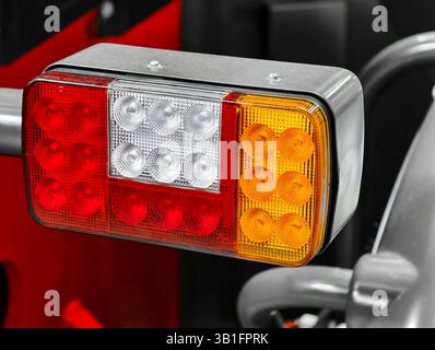 Ensemble de feux de tracteur aux couleurs vives présentant des détails de conception complexes dans une installation de stockage agricole pendant l'heure dorée Banque D'Images