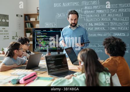 Enseignant guider les élèves en classe avec des ordinateurs Banque D'Images