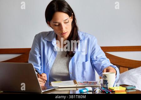 femme de 35 ans étudiant à la maison. Banque D'Images