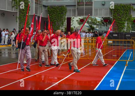 Singapour 2025 avr23 - jour de la nomination aux élections générales. Groupe de partisans du SDP portant des drapeaux marchent dans le Centre de nomination à l'école de Chongfu, à l Banque D'Images