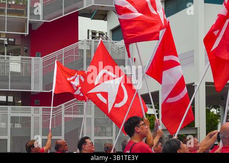 Singapour 2025 avr23 - les partisans du SDP revêtent des drapeaux de parti en vague rouge à l'école de Chongfu le jour de la nomination lors des élections générales de Singapour pour Sembawa Banque D'Images