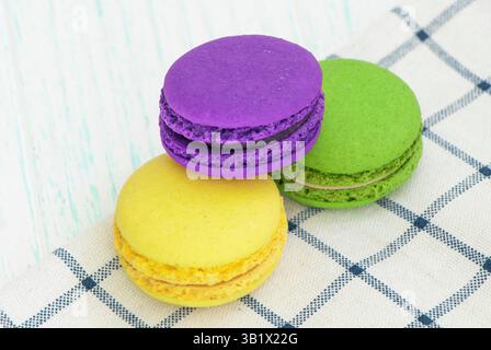 gâteaux aux macarons multicolores sur une serviette à carreaux. macarons rouges, verts, jaunes Banque D'Images