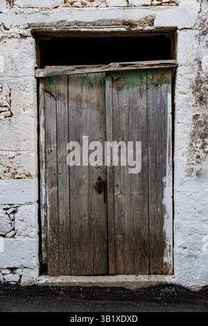 Mur blanc détruit de bâtiment abandonné avec porte en bois Banque D'Images