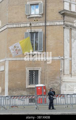Rome, Italie. 26 avril 2025. Le drapeau de la Cité du Vatican est en Berne alors qu'une femme officier de police de la capitale de Rome parle au téléphone, appuyée contre une barrière à l'extérieur de l'église de Santa Maria Maggiore, fermée pour l'enterrement du pape François à Rome. Après l'arrivée du cercueil du pape François à la basilique de Santa Maria Maggiore, le processus d'enterrement du cercueil a commencé, qui a duré 30 minutes, de 13h00 à 13h30 (crédit image : © Marcello Valeri/ZUMA Press Wire) USAGE ÉDITORIAL SEULEMENT ! Non destiné à UN USAGE commercial ! Crédit : ZUMA Press, Inc/Alamy Live News Banque D'Images