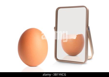 Oeuf entier réfléchissant dans le miroir comme fissuré, fond blanc. Opposé, contraste, différence Banque D'Images