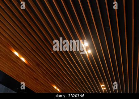Downlight LED installé entre le plafond à lattes en bois, créant un éclairage festonné Banque D'Images