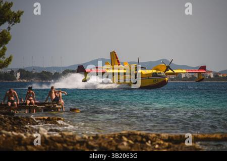 Un avion croate de lutte contre les incendies Canadair CL-415 ramassant de l'eau dans la mer lors d'une mission de feu de forêt. Banque D'Images
