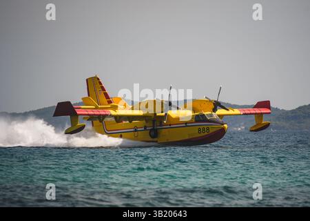 Un avion croate de lutte contre les incendies Canadair CL-415 ramassant de l'eau dans la mer lors d'une mission de feu de forêt. Banque D'Images
