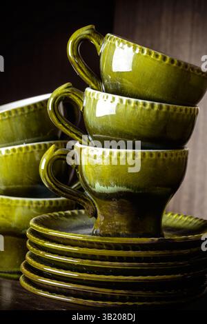 Service à café vintage à thé glacé. Céramique rétro poterie set tasses et soucoupes couleurs vert automne sur fond en bois Banque D'Images