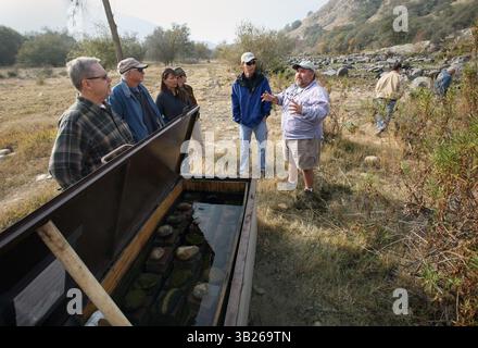 06, 2009 - PIEDRA, CA, USA - PIEDRA, CA 12/6/09 MTD CEK FIGHTERS COLLECTE DE FONDS. Freddie Ramirez, à droite, un officier de la Fly Fishers for conservation, explique aux visiteurs le programme de pêche à la truite sur la rivière Lower Kings près du barrage de Pine Flat le dimanche 6 décembre 2009. Les pêcheurs à la mouche et les individus locaux ont pu observer de près un incubateur de truites, à gauche, en action où des milliers d'œufs de poisson couvaient dans une boîte d'incubateur côté ruisseau. Environ 50 amateurs de pêche à la mouche se sont réunis pour un barbecue et une éducation à la pêche afin de sensibiliser davantage à la pêche à la truite de la rivière et de recueillir des fonds pour le bœuf Banque D'Images