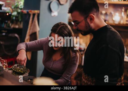 Deux personnes préparant les ingrédients ensemble dans un environnement de bar confortable Banque D'Images