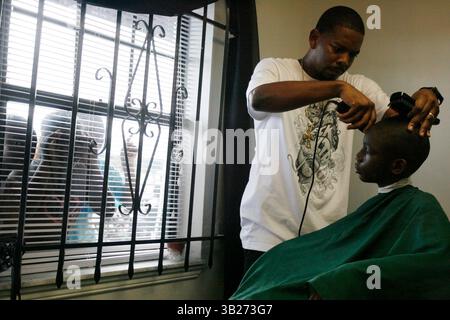 CHRIS ZUPPA | Times. SP 310907 ZUPP Feature 1 (08/23/2009 caractérisée Petersburg) Barber bénévole DonQuan (cq) Ware of résolu Petersburg coupe les cheveux de Trenton Torkes, neuf ans, pendant que les enfants du quartier regardent au Silverliner Beauty Center. Torkes of, Petersburg entre en troisième année. Silverliner et Tabatha's Exquisite Touch salon ont fait don de coupes de cheveux à au moins 300 enfants, allant de la maternelle aux seniors du secondaire. Il y a quatre ans, Consuelo Mackey a commencé à donner des coupes de cheveux gratuites aux enfants de la rentrée scolaire. ''J'étais un enfant moins chanceux'', a déclaré Mackey, qui possède Tabatha's et a fondé The Even Banque D'Images