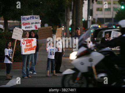 FRESNO, CA. 11/6/9 POLICE EPZ MTD FAMILLE VARGAS les membres de la famille de Steven Vargas se tiennent à l'angle des rues Fresno et M en face de la prison du comté de Fresno agitant des pancartes à la circulation de passage appelant au licenciement du chef de la police de Fresno Jerry Dyer vendredi soir au crépuscule, le 6 novembre 2009. Vingt-sept personnes s'étaient rassemblées devant les médias au siège du département de police de Fresno pour une conférence de presse critiquant le chef de la police de Fresno et qualifiant les politiques du département de police de racistes. Après les discours prononcés lors de la conférence de presse, le groupe a marché à un pâté de maisons jusqu'au l de la prison Banque D'Images