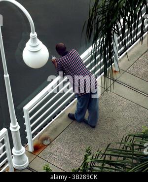 CHERIE DIEZ | Times. SP 311503 DIEZ Feature 1 de 1 (09/03/2009 ST. PETERSBURG) Paul Jackson une pause de son travail pour surveiller le port de Bayboro et appeler sa femme, Gina. Jackson vérifie les documents juridiques à la Direction des permis du National Marine Fishing services à Bayboro Station. Il les appelle ''le soleil se brise'' quand il y a du soleil. Aujourd'hui était plus frais et gris, mais il a dit qu'il préférerait beaucoup avoir une chaude journée claire avec des nuages blancs gonflés dans le ciel. ''comme l'image d'arrière-plan du logiciel Windows'', a-t-il dit. (NOTEZ QUE l'image fantôme est due au fait que la photo a été prise à travers une fenêtre.) [CHERIE DIEZ, Times] (Cr Banque D'Images