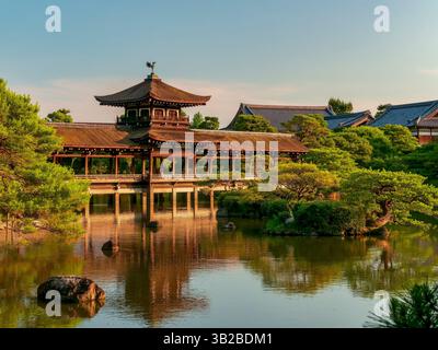 Pavillon japonais historique entouré de jardins et d'un étang au coucher du soleil, situé à Kyoto, Japon. Architecture traditionnelle immergée dans la nature. Banque D'Images
