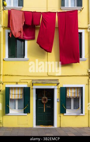 Maison jaune avec linge rouge suspendu à Burano Italie Banque D'Images