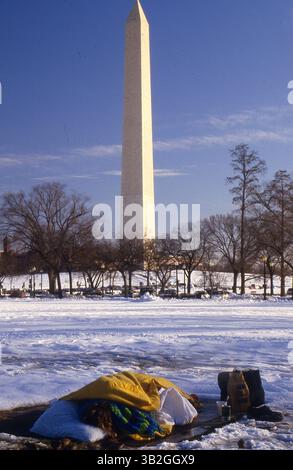 23 septembre 2013 - Washington, District of Columbia, États-Unis d'Amérique - Washington DC non daté . Homme sans-abri dort sur un évent de vapeur entouré de neige avec le Washington Monument en arrière-plan..crédit : Mark Reinstein (crédit image : © Mark Reinstein via ZUMA Wire) Banque D'Images