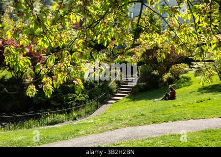 Deux personnes profitant du soleil printanier, Priory Park, Great Malvern, Worcestershire, Royaume-Uni. 2025 Banque D'Images