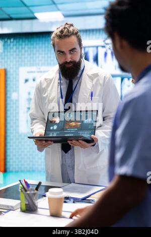 Expert en neurosciences examinant les résultats de l'irm cérébrale avec des médecins, discutant du plan de traitement approprié pour la prévention de la maladie. Un neurologue agréé et son personnel examinent la tomographie. Banque D'Images