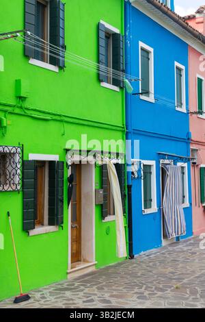 Maisons colorées avec des façades vertes et bleues et des volets à Burano Italie Banque D'Images