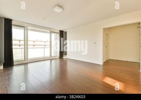 Cette chambre moderne spacieuse et vide dispose de grandes fenêtres, de lumière naturelle et de parquet ciré, idéale pour inspirer le design d'intérieur. Banque D'Images