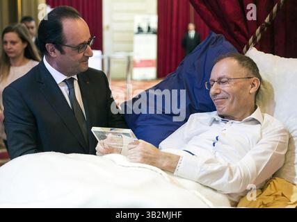 22 décembre 2015 - Paris, FRANCE - le président français François Hollande discute avec le lauréat Claude Emmanuel Triomphe, allongé sur un lit alors qu'il était blessé dans les attentats du 13 novembre à Paris, de son projet dessine moi le travail lors de la cérémonie des lauréats ''la France s' engage'' au Palais de l'Elysée à Paris, mardi 22 décembre 2015. L’événement récompense des citoyens, des fondations, des entreprises ou des associations qui innovent et accompagnent l’avancement de la société française. (Crédit image : © Prensa Internacional via ZUMA Wire) Banque D'Images