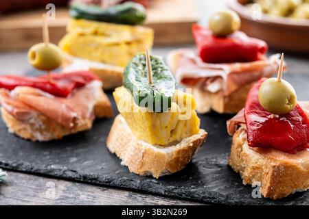 Pintxos espagnols traditionnels sur table en bois Banque D'Images