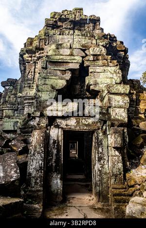 Ruines de temple en pierre anciennes avec des surfaces couvertes de mousse, avec des sculptures complexes et de multiples portes menant à des couloirs sombres. Le ciel fait partie Banque D'Images