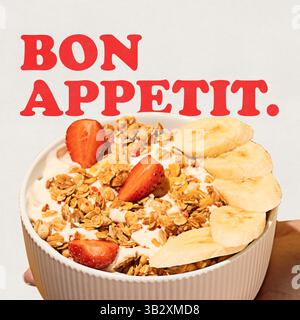 Bol de granola avec yaourt, fraises et tranches de banane créant un plat délicieux et sain pour le petit déjeuner. Texte en gras. Création conceptuelle. Banque D'Images
