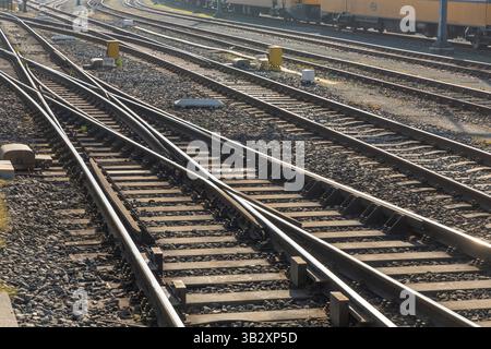 Gros plan des voies ferrées et des aiguillages dans une gare de triage aux pays-Bas, pris par une journée ensoleillée. La photo montre des rails en acier croisés et du gravier Banque D'Images