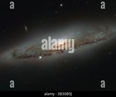 Jan 8, 2016 - espace - une image du télescope spatial Hubble de la NASA/ESA capture la galaxie spirale NGC 4845, située à plus de 65 millions d'années-lumière dans la constellation de la Vierge. L'orientation de la galaxie révèle clairement une structure spiralée frappante : un disque plat et moucheté de poussière entourant un renflement galactique brillant. Le centre lumineux de NGC 4845 accueille une version gigantesque d'un trou noir, connu sous le nom de trou noir supermassif. (Crédit image : © ESA/Hubble/NASA/ZUMAPRESS.com) Banque D'Images
