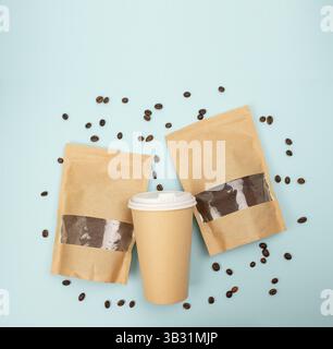 Emballage de café affiché avec café moulu et grains sur une surface bleue propre, vue de dessus. Pose à plat. Banque D'Images