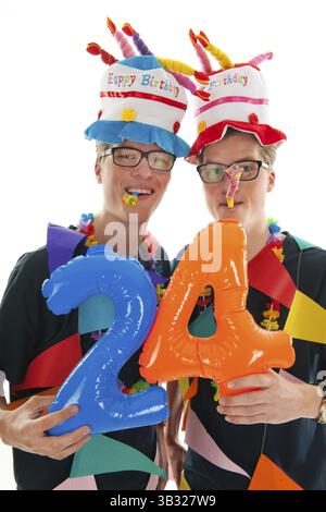Chez les hommes adultes ayant des jumeaux à l'identique en studio d'anniversaire Banque D'Images