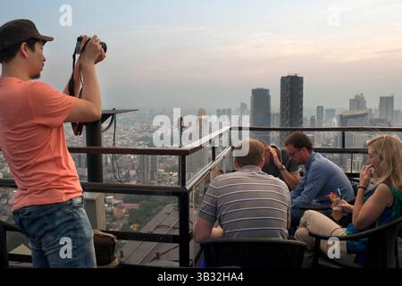 Dec 2, 2015 - Bangkok, Thaïlande - paysage, vues. Banyan Tree Rooftop Vertigo & Moon Bar, Restaurant, , Bangkok , Thaïlande. Vue sur la ville, bar et restaurant Vertigo, toit de l'hôtel Banyan Tree, au crépuscule Bangkok, Thaïlande, Asie. Atteindre les nuages au Vertigo et Moon Bar, au 61e étage de l'hôtel Banyan Tree, est l'un des meilleurs moyens de terminer une longue journée à Bangkok. Il ne manque pas de bars sur les toits en ville, mais Vertigo a toujours été parmi les favoris. Avec une forme étroite et allongée inhabituelle, tout le sommet du bâtiment est occupé à la fois par le bar et le restaurant et Banque D'Images