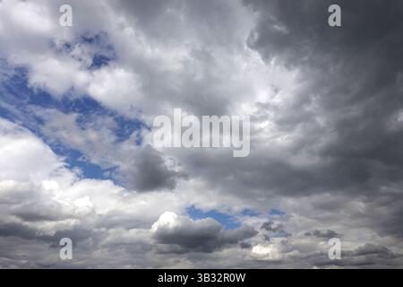Paysage paradisiaque avec un temps de tempête couvert avec des nuages pluvieux gris dramatiques et lourds cumulus et un petit ciel bleu Banque D'Images