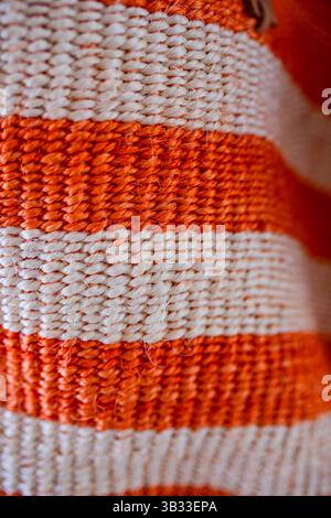 Sisal tissé à la main en orange vif et blanc. Banque D'Images