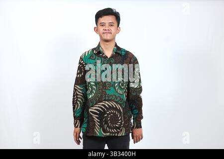 homme asiatique portant chemise de batik souriant isolé sur fond blanc Banque D'Images
