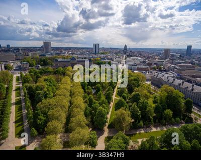 Bruxelles vu d'en haut : le vert urbain rencontre l'architecture historique. Oasis urbaine de Brussels Park contraste avec l'horizon de la ville sous des nuages spectaculaires. Banque D'Images