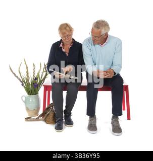 Couple senior assis dans la salle d'attente isolée sur fond blanc Banque D'Images